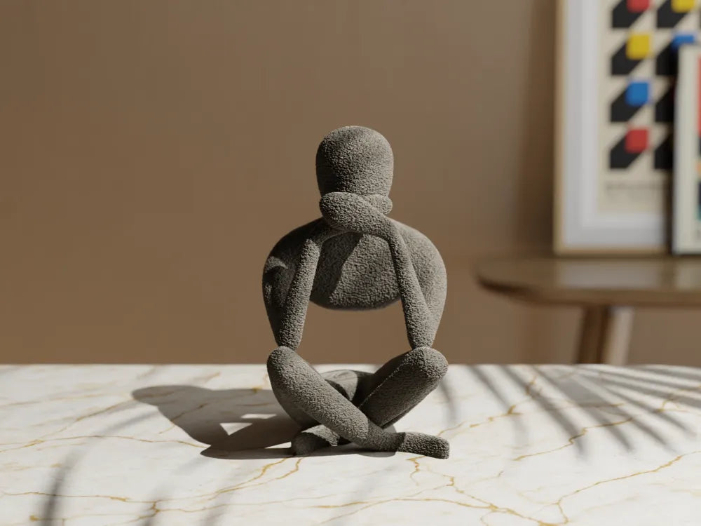 Figurine penseur abstrait grise seule, vue de face, mains sur les oreilles