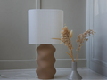 Luminaire Dune présenté près d’un vase de fleurs séchées
