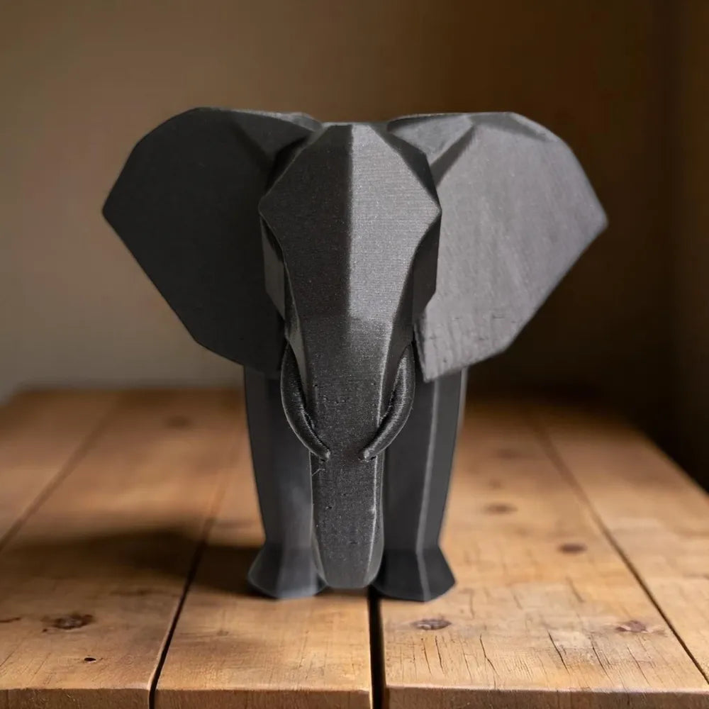 Sculpture éléphant géométrique vue de face sur table en bois