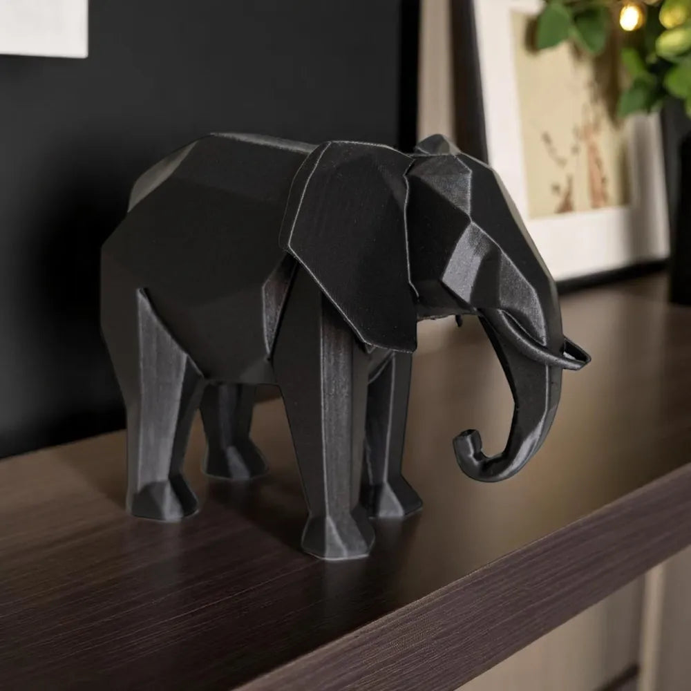Sculpture éléphant géométrique noir sur étagère foncée, vue de profil