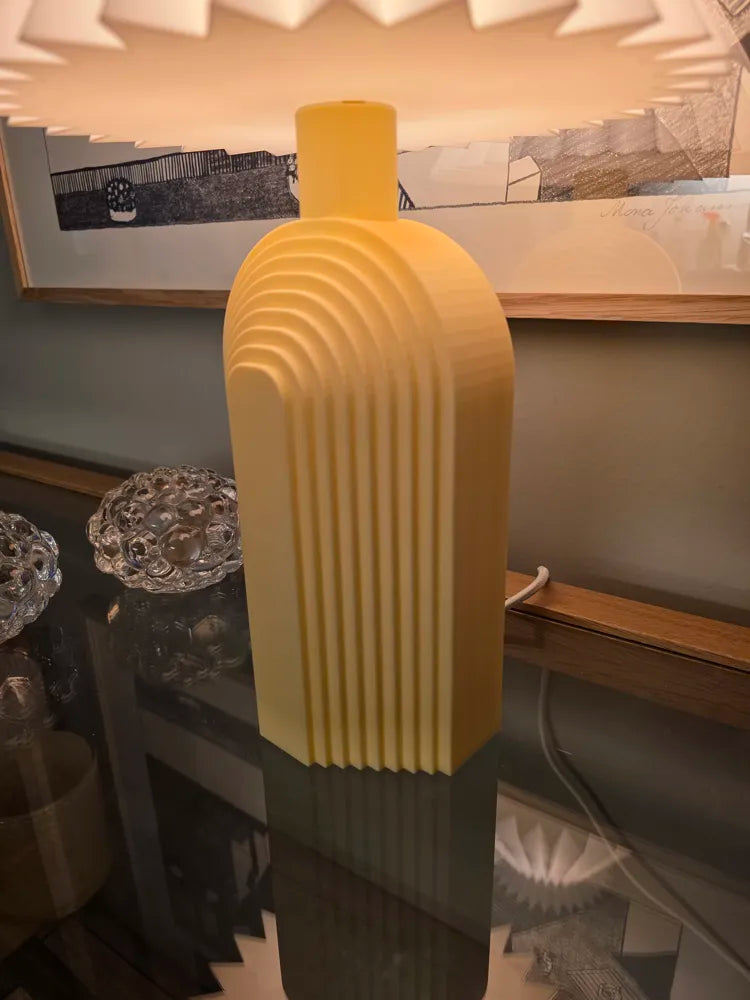 Détail du pied jaune du luminaire Arche et de ses reliefs arrondis