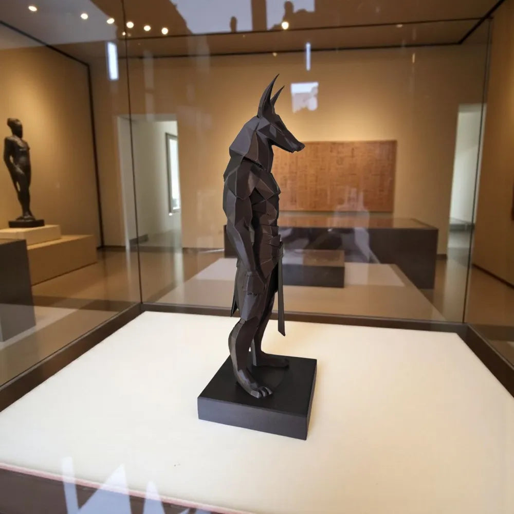 Sculpture Anubis low-poly noir en galerie, vue de profil