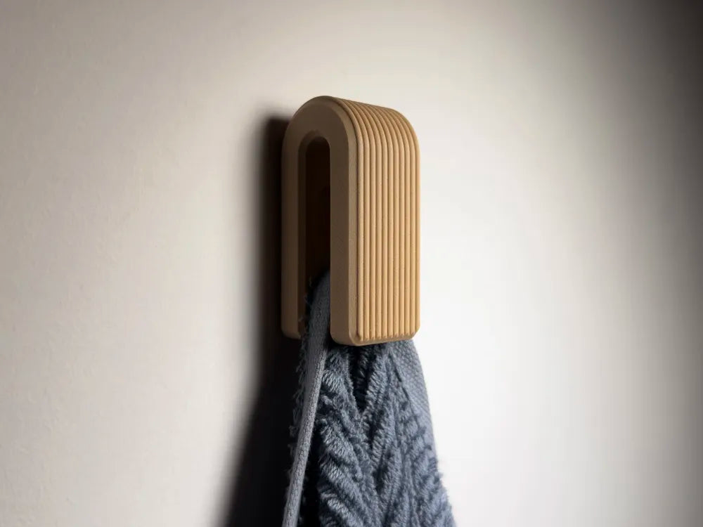Porte-serviette mural cannelé beige avec une serviette grise