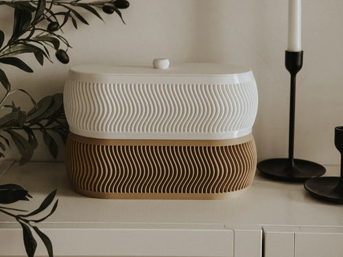 Boîte ronde à couvercle motif ondulé bicolore blanc et beige sur console