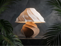 Luminaire Tourbillon au pied brun torsadé et abat-jour clair ondulé, entouré de plantes