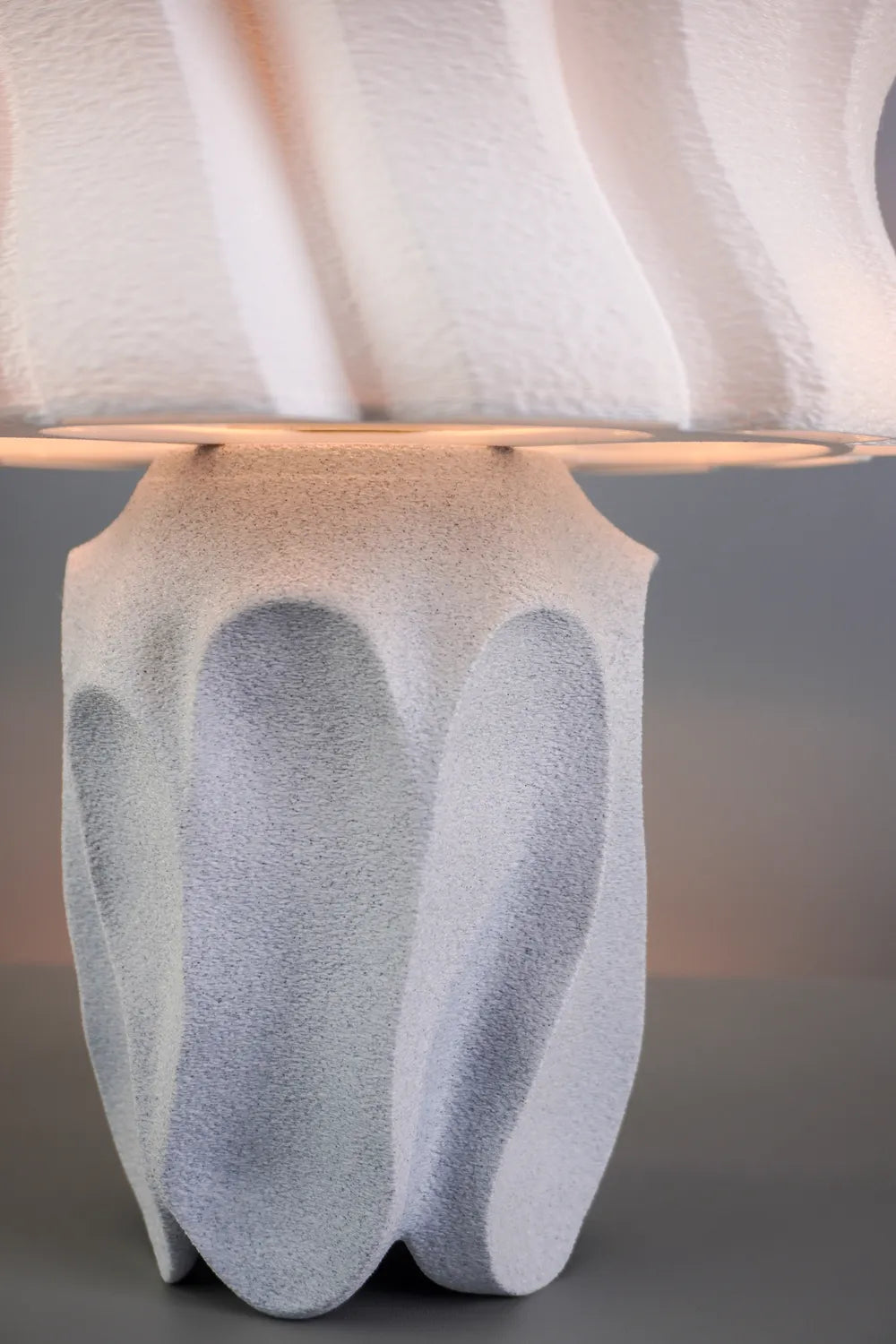 Détail des creux arrondis et de la surface texturée du pied du luminaire Calice