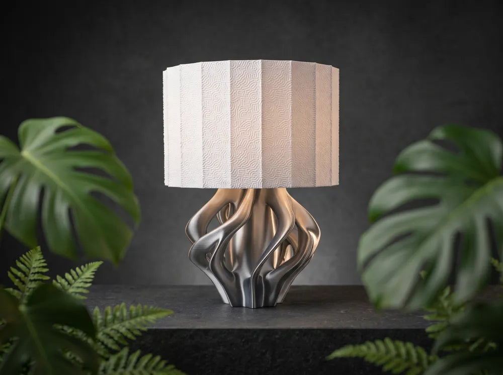 Luminaire Sillage au pied aux reflets argentés et aux courbes ajourées
