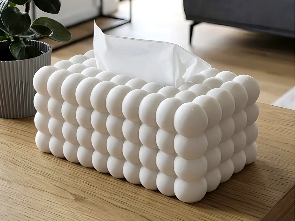 Boîte à mouchoirs blanche au relief de bulles arrondies sur une table en bois