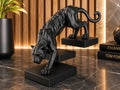Sculpture panthère noire en descente sur socles étagés, ambiance luxe marbre