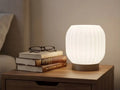 Luminaire Opale blanc nervuré présenté sur une table de chevet