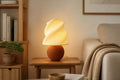 Luminaire Brise au pied brun arrondi et abat-jour clair ondulé
