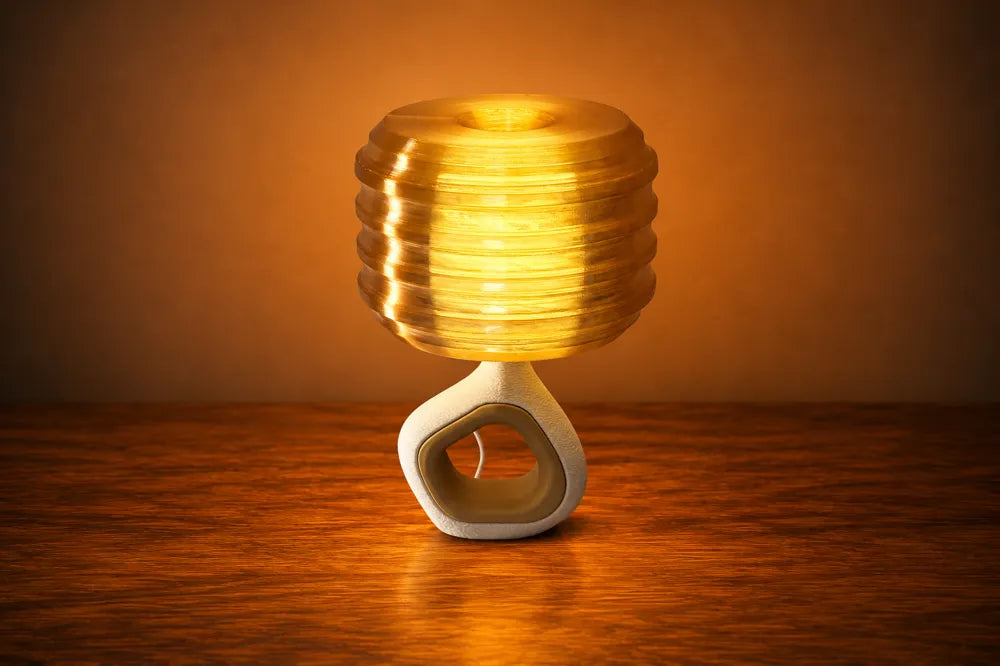 Luminaire Ambre à abat-jour doré et pied clair à ouverture centrale